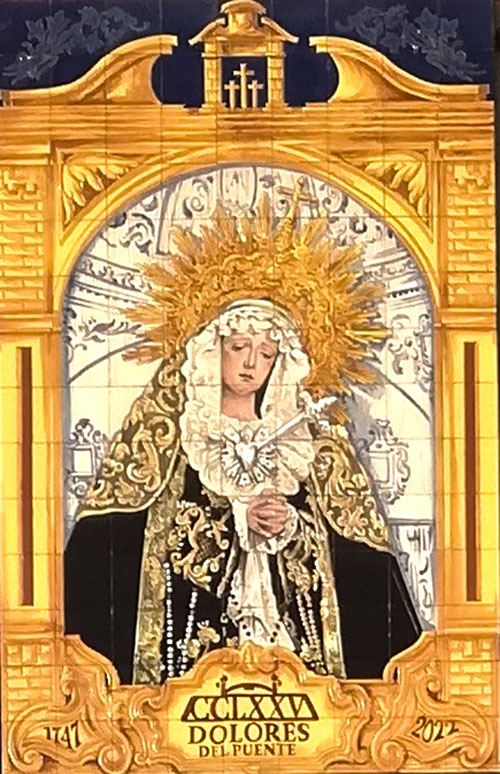 Cerámica conmemorativa del 275 aniversario de Nuestra Señora de los Dolores del Puente, situada en la fachada de un edificio del Pasillo de Atocha, frente al Puente de los Alemanes